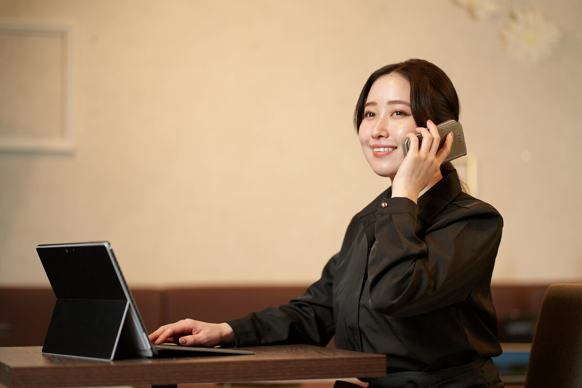 店内のカウンターで、タブレットを見ながら電話で予約を受けるお店の方